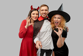 Image showing happy friends in halloween costumes taking selfie