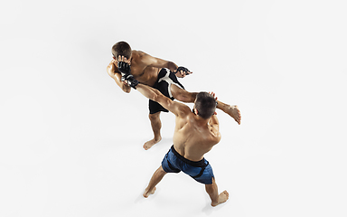 Image showing Two professional MMA fighters boxing isolated on white studio background, dynamic and motion. Top view