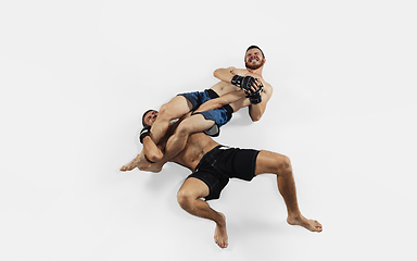 Image showing Two professional MMA fighters boxing isolated on white studio background, dynamic and motion. Top view