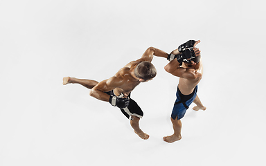 Image showing Two professional MMA fighters boxing isolated on white studio background, dynamic and motion. Top view