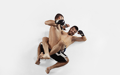 Image showing Two professional MMA fighters boxing isolated on white studio background, dynamic and motion. Top view