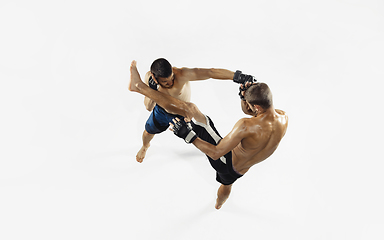 Image showing Two professional MMA fighters boxing isolated on white studio background, dynamic and motion. Top view