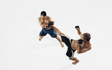 Image showing Two professional MMA fighters boxing isolated on white studio background, dynamic and motion. Top view