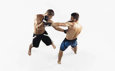 Image showing Two professional MMA fighters boxing isolated on white studio background, dynamic and motion. Top view