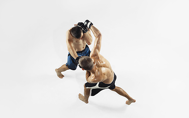 Image showing Two professional MMA fighters boxing isolated on white studio background, dynamic and motion. Top view