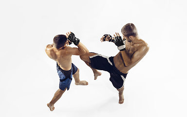 Image showing Two professional MMA fighters boxing isolated on white studio background, dynamic and motion. Top view