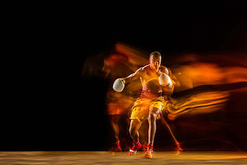 Image showing Professional boxer training isolated on black studio background in mixed light