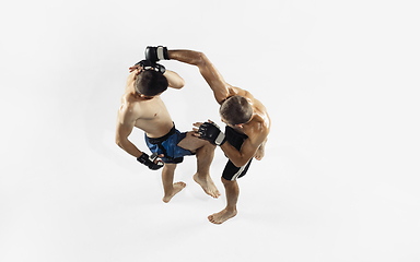 Image showing Two professional MMA fighters boxing isolated on white studio background, dynamic and motion. Top view