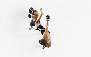 Image showing Two professional MMA fighters boxing isolated on white studio background, dynamic and motion. Top view