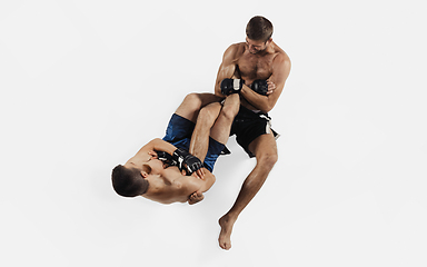 Image showing Two professional MMA fighters boxing isolated on white studio background, dynamic and motion. Top view