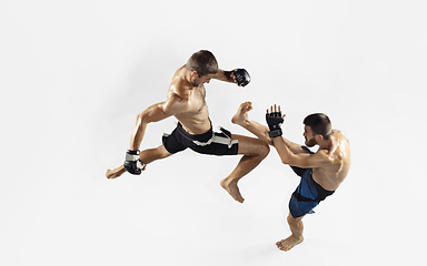 Image showing Two professional MMA fighters boxing isolated on white studio background, dynamic and motion. Top view