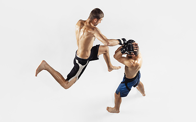 Image showing Two professional MMA fighters boxing isolated on white studio background, dynamic and motion. Top view