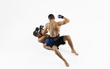 Image showing Two professional MMA fighters boxing isolated on white studio background, dynamic and motion. Top view