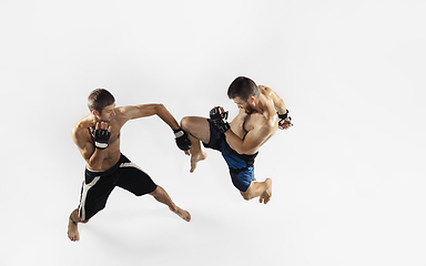 Image showing Two professional MMA fighters boxing isolated on white studio background, dynamic and motion. Top view