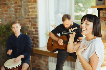 Image showing Musician band jamming together in art workplace with instruments