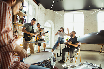 Image showing Musician band jamming together in art workplace with instruments