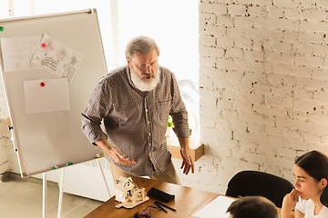 Image showing Male architect-engineer presents project of future house for young family.