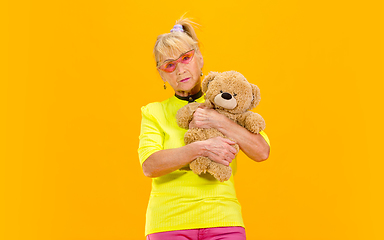 Image showing Senior woman in ultra trendy attire isolated on bright orange background