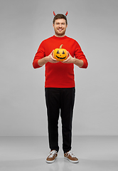 Image showing happy man in halloween costume of devil over grey