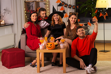 Image showing happy friends in halloween costumes taking selfie