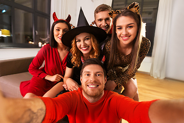 Image showing happy friends in halloween costumes taking selfie