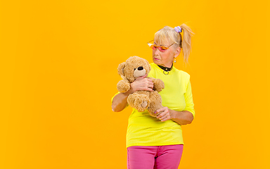 Image showing Senior woman in ultra trendy attire isolated on bright orange background