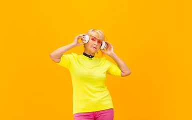 Image showing Senior woman in ultra trendy attire isolated on bright orange background