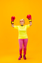 Image showing Senior woman in ultra trendy attire isolated on bright orange background