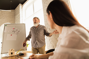 Image showing Male architect-engineer presents project of future house for young family.