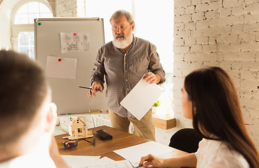 Image showing Male architect-engineer presents project of future house for young family.