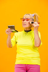 Image showing Senior woman in ultra trendy attire isolated on bright orange background