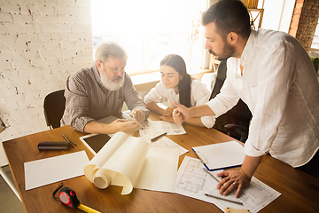 Image showing Male architect-engineer presents project of future house for young family.