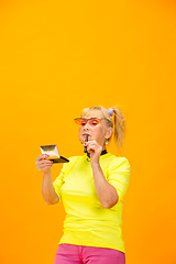 Image showing Senior woman in ultra trendy attire isolated on bright orange background