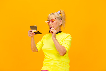 Image showing Senior woman in ultra trendy attire isolated on bright orange background