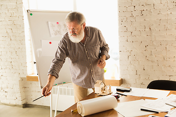 Image showing Male architect-engineer presents project of future house for young family.