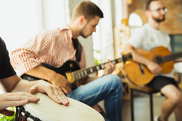 Image showing Musician band jamming together in art workplace with instruments