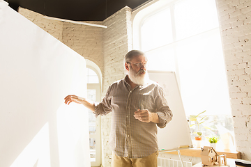 Image showing Male architect-engineer presents project of future house for young family.