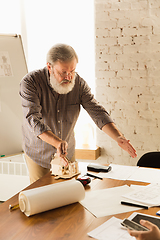 Image showing Male architect-engineer presents project of future house for young family.