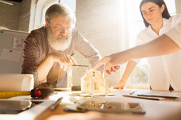 Image showing Male architect-engineer presents project of future house for young family.