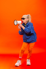 Image showing Senior woman in ultra trendy attire isolated on bright orange background