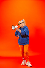 Image showing Senior woman in ultra trendy attire isolated on bright orange background