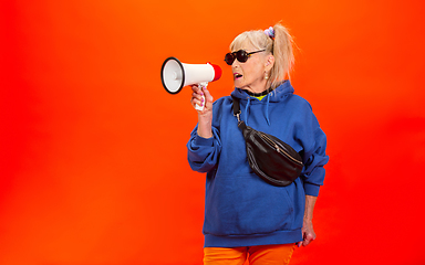 Image showing Senior woman in ultra trendy attire isolated on bright orange background