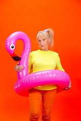 Image showing Senior woman in ultra trendy attire isolated on bright orange background