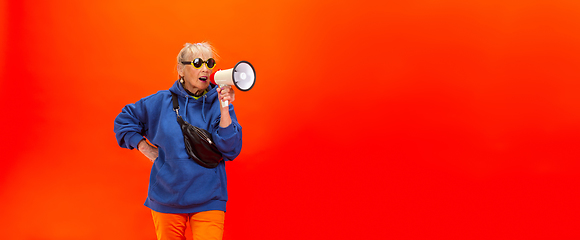 Image showing Senior woman in ultra trendy attire isolated on bright orange background