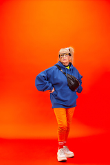 Image showing Senior woman in ultra trendy attire isolated on bright orange background