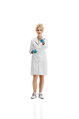 Image showing Portrait of female doctor, nurse or cosmetologist in white uniform and blue gloves over white background