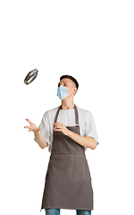 Image showing Isolated portrait of a young male caucasian barista or bartender in brown apron smiling