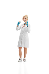 Image showing Portrait of female doctor, nurse or cosmetologist in white uniform and blue gloves over white background