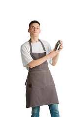 Image showing Isolated portrait of a young male caucasian barista or bartender in brown apron smiling
