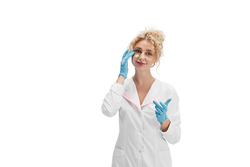 Image showing Portrait of female doctor, nurse or cosmetologist in white uniform and blue gloves over white background